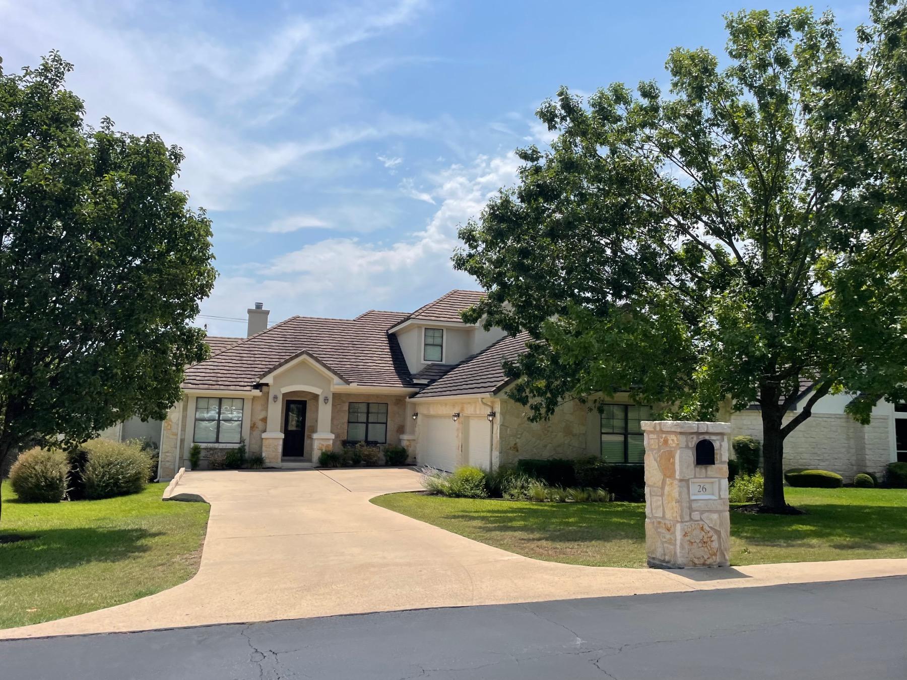 The Hills Lakeway one-story home with mature trees and Hill Country views