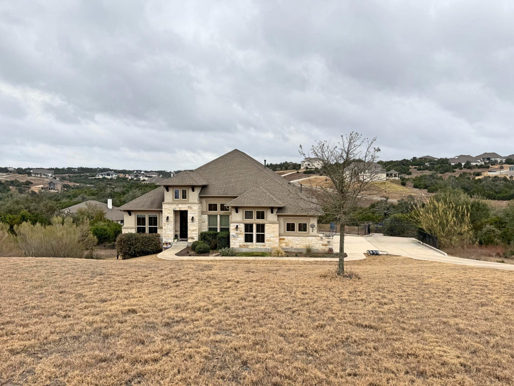 Saratoga Hills Austin luxury home sitting below street with neighborhood view