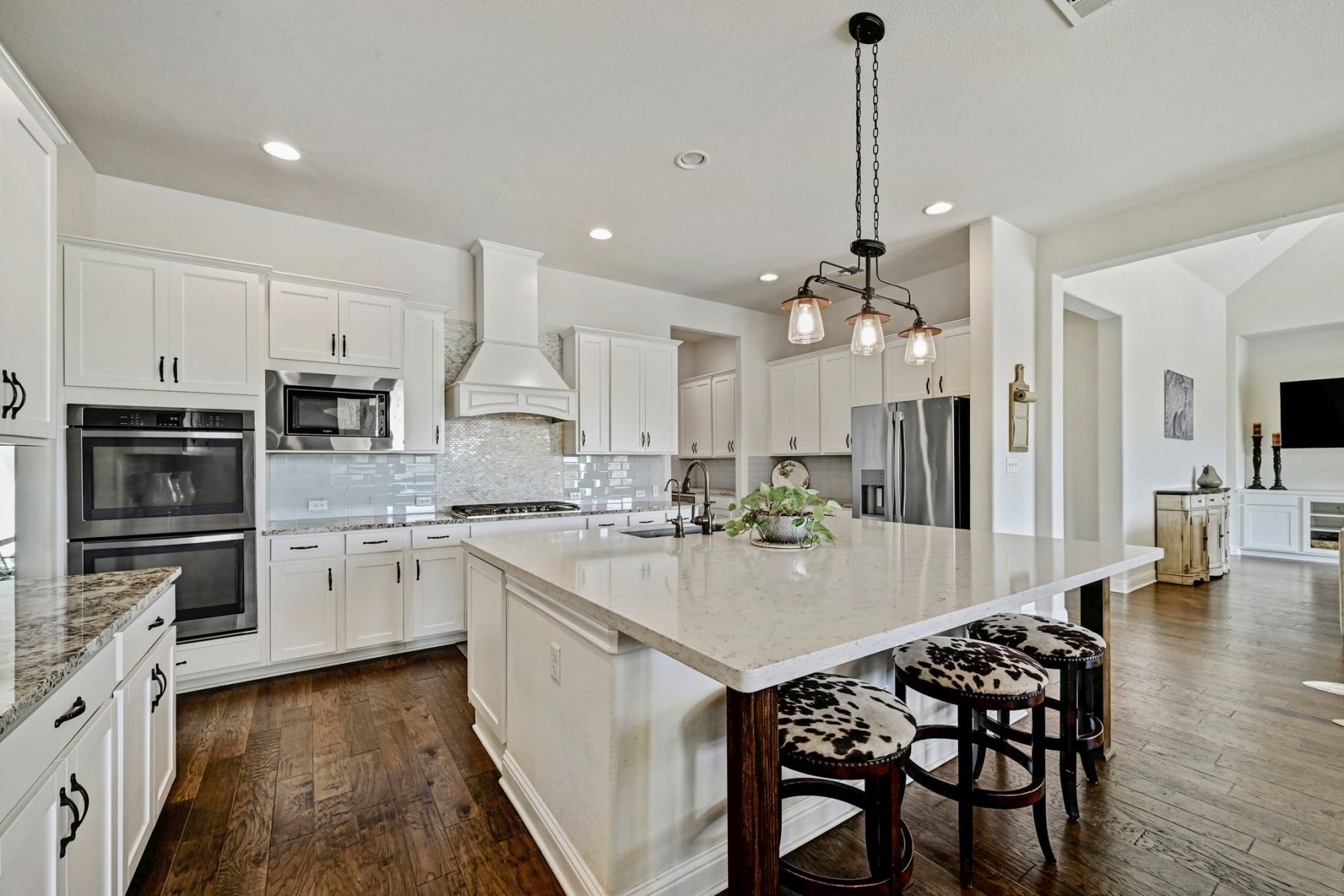 Modern kitchen with stainless appliances double ovens and large island in an Austin Texas home