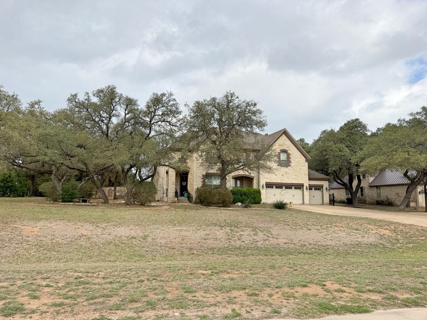 Limestone home with large garage and sprawling lawn in Rim Rock Driftwood TX 78619