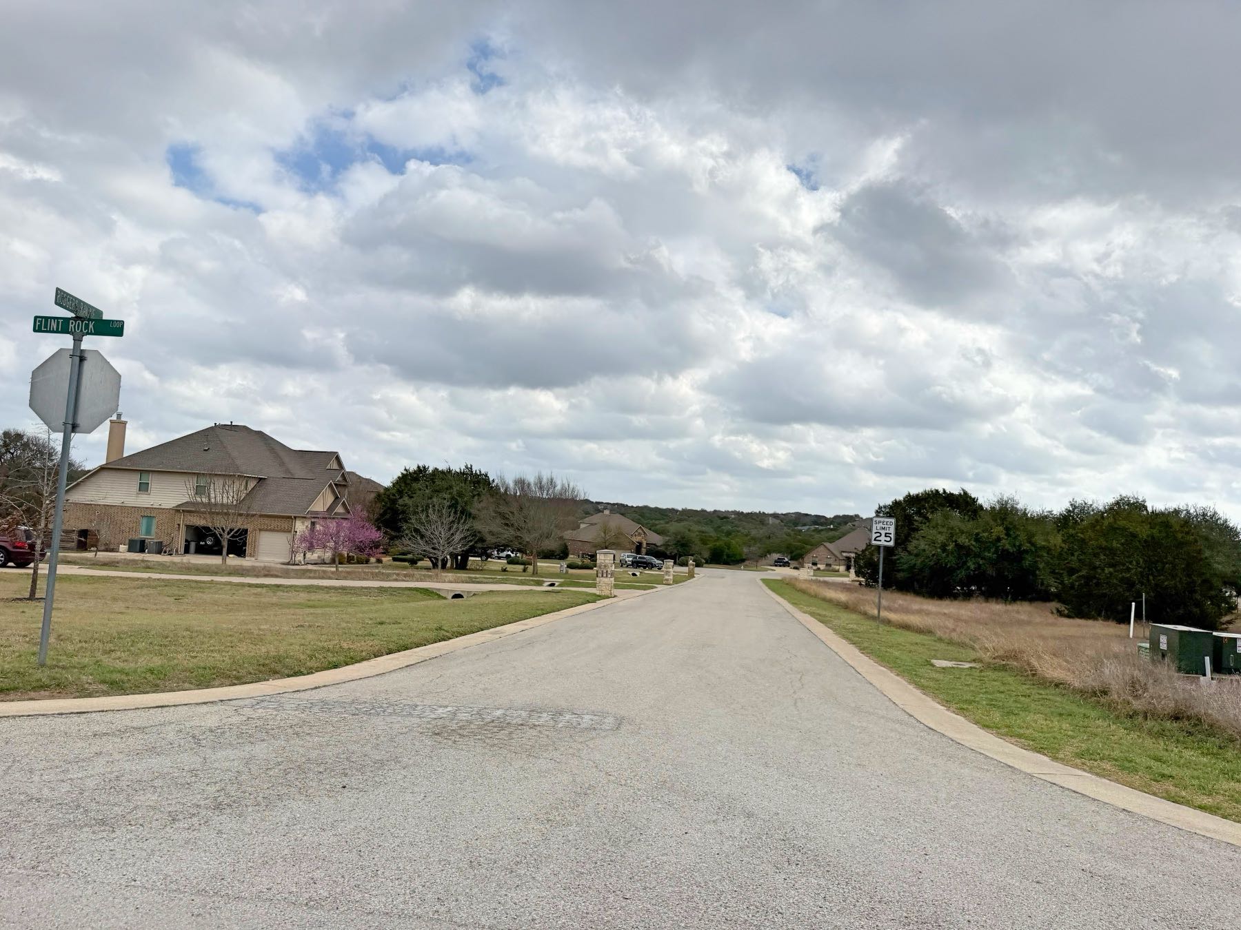 Rim Rock neighborhood street with scenic hill views in Driftwood TX 78619