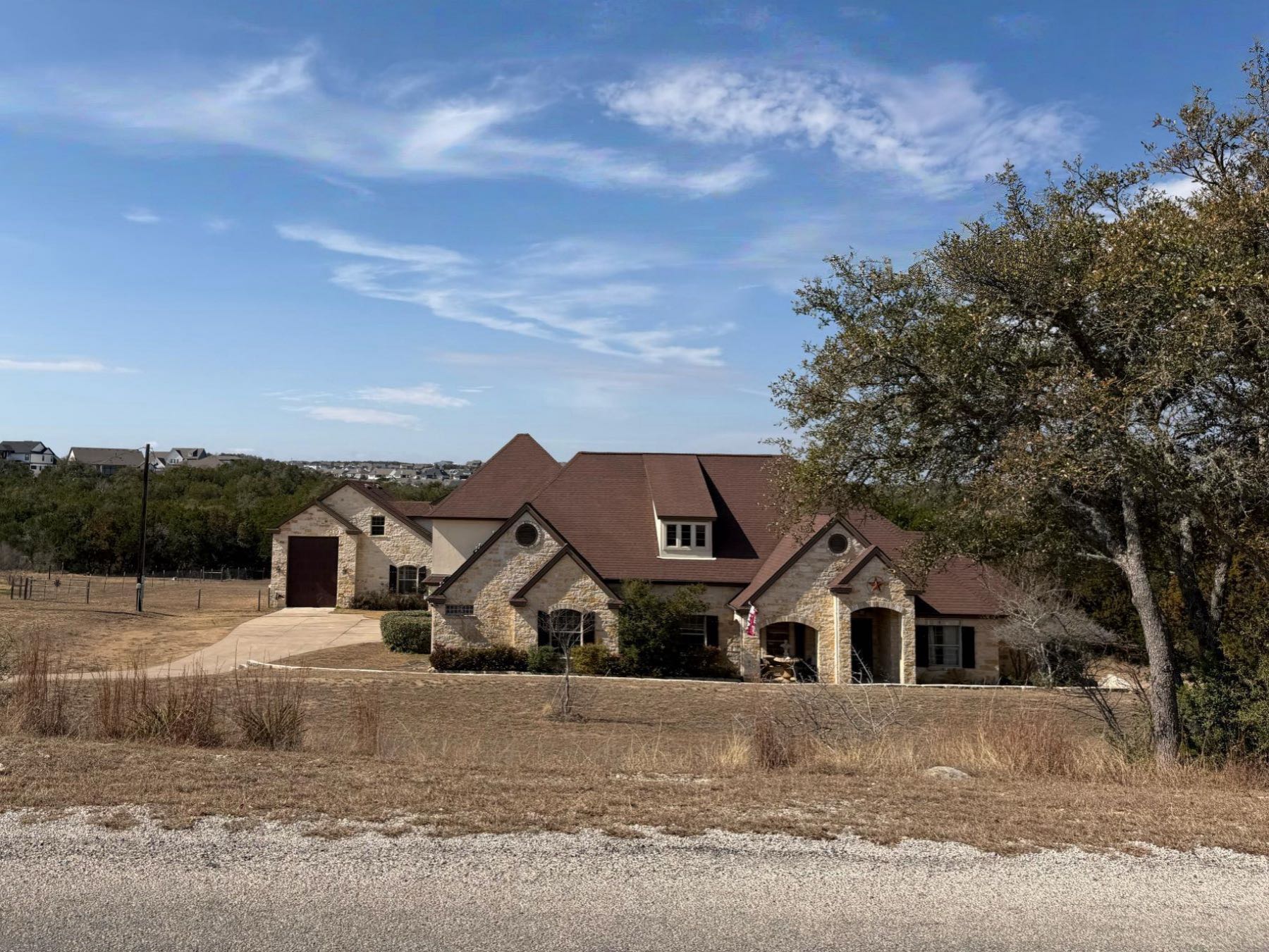 Luxury stone home with oversized RV garage on elevated acreage lot in Sunset Canyon, Dripping Springs TX 78620