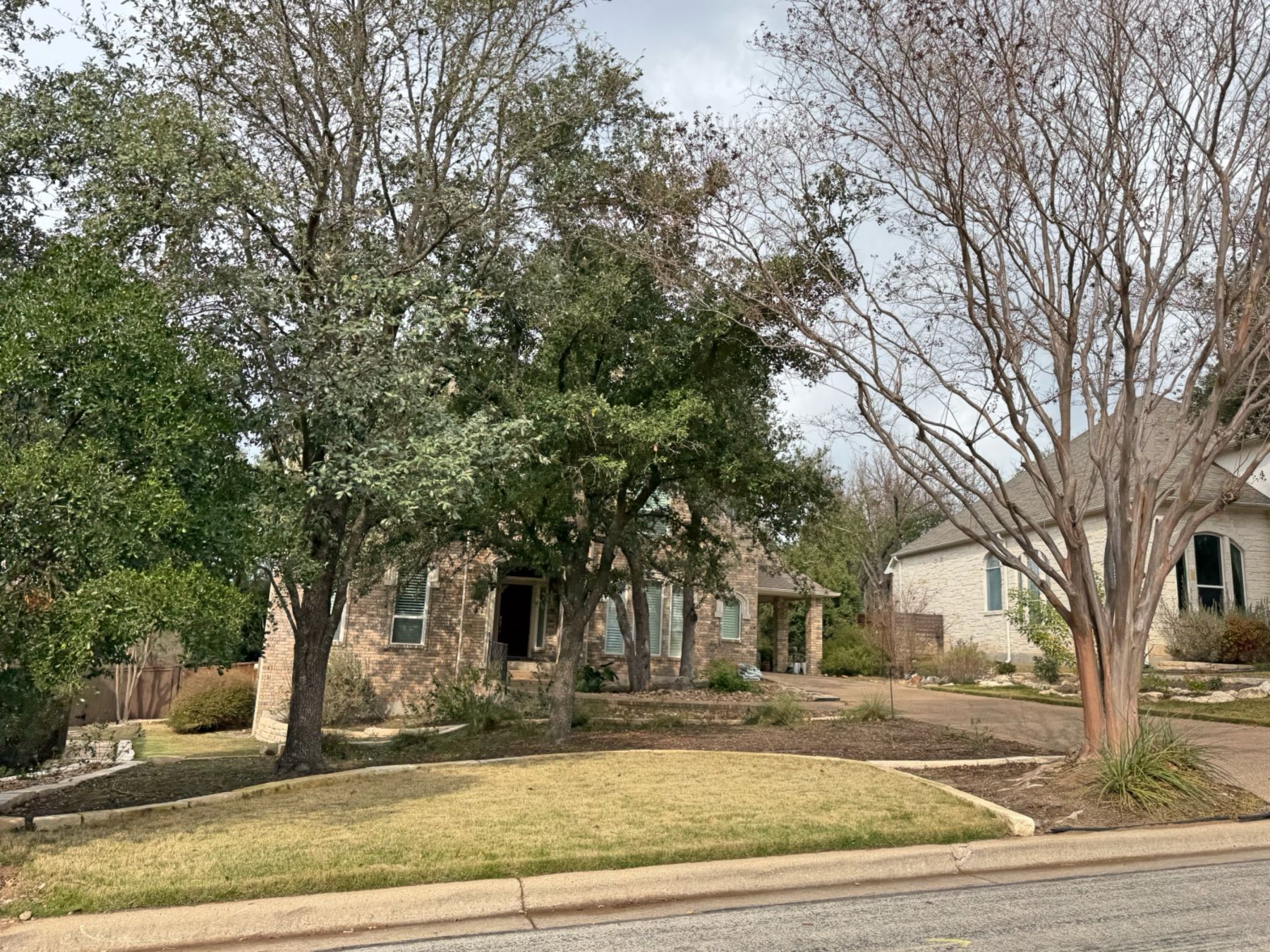 One story stone home with beautifully landscaped yard and mature trees in Great Hills Austin TX
