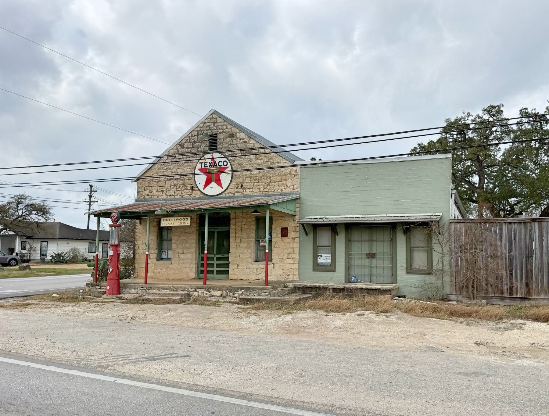 Historic Texaco gas station with vintage red star sign and old fuel pumps on a stone building in Driftwood, Texas 78619