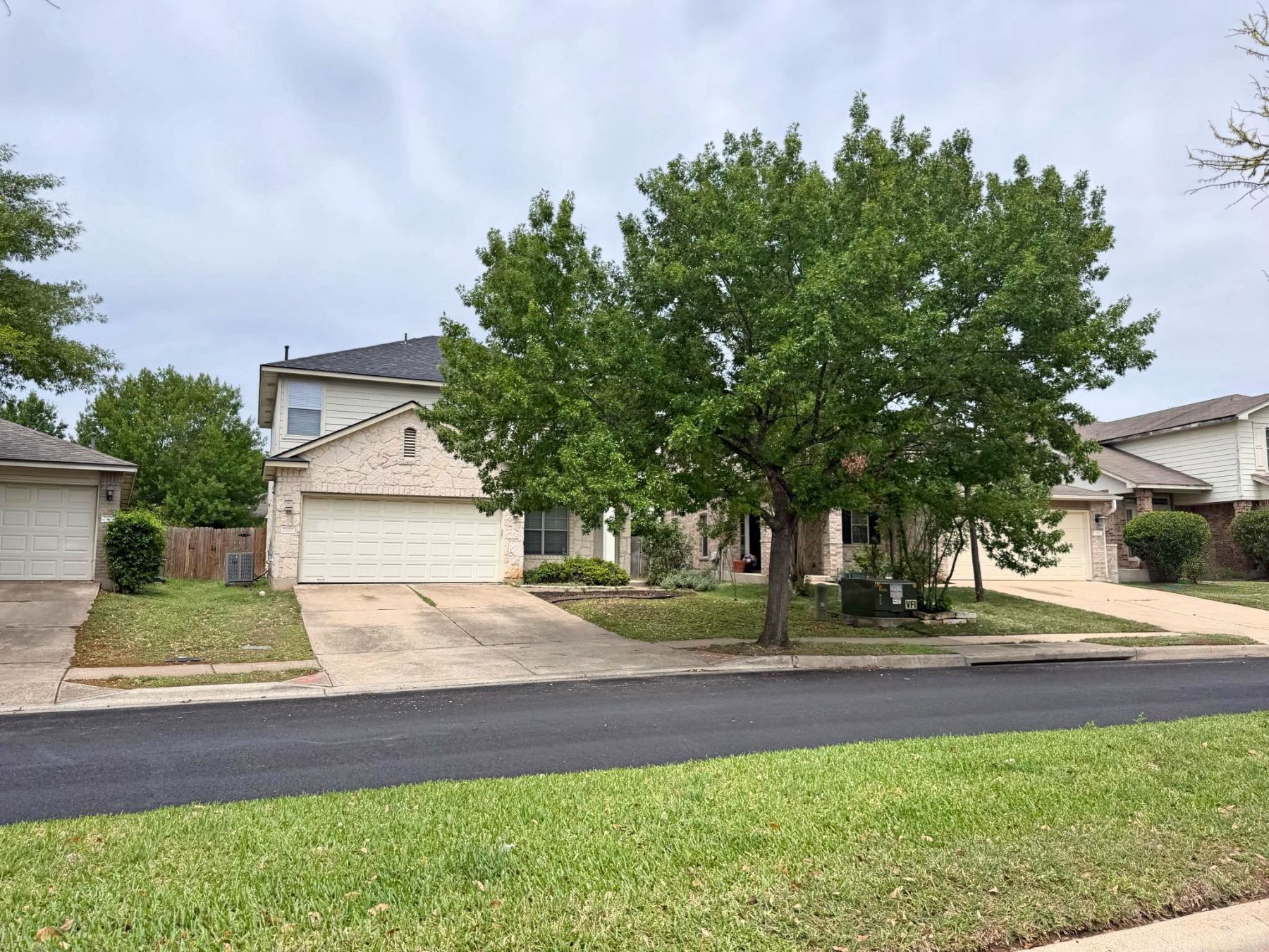 Two story stone and siding homes side by side with two car garages in Olympic Heights Austin TX 78748