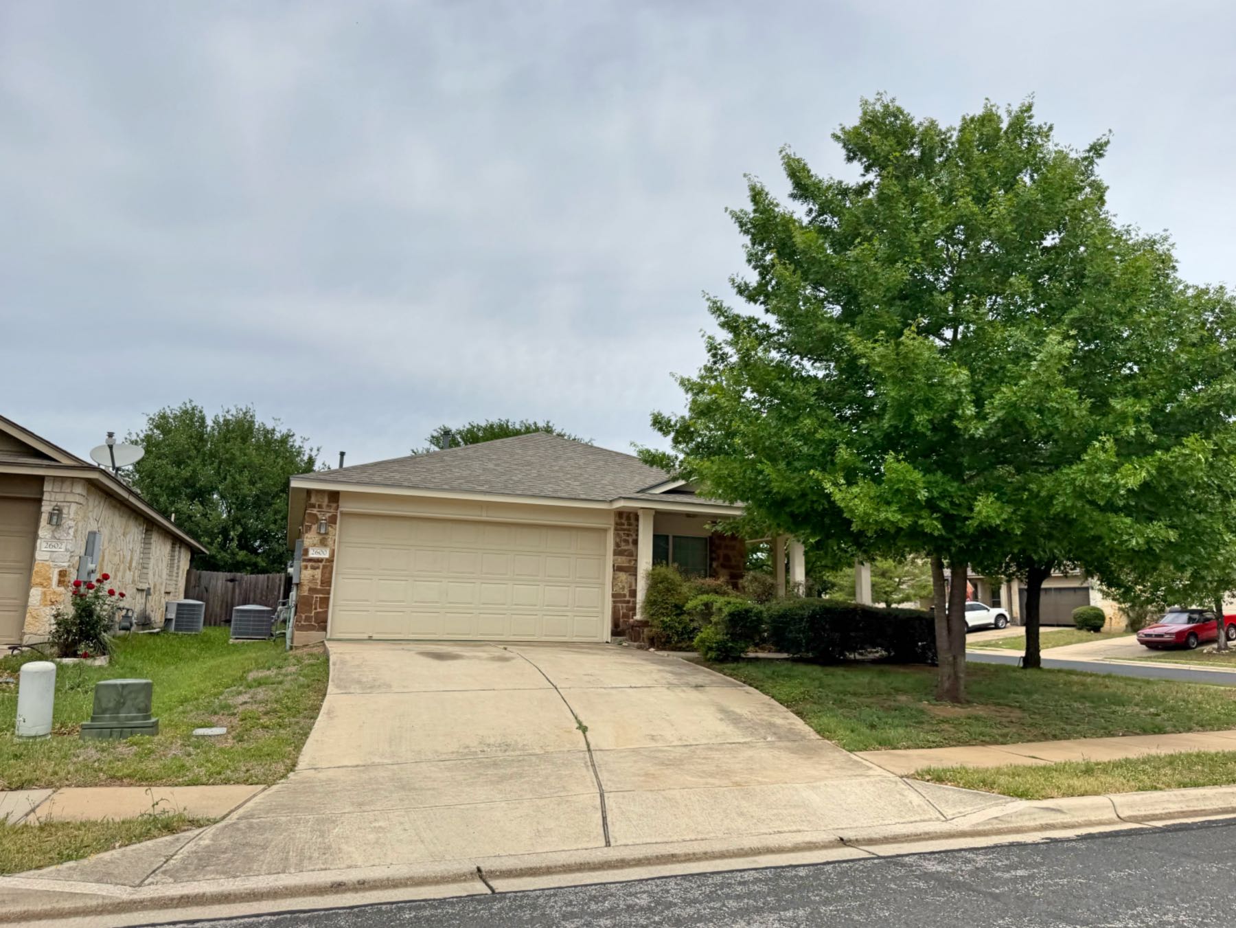 Single story home on corner lot with large shade tree in Olympic Heights West Austin TX 78748