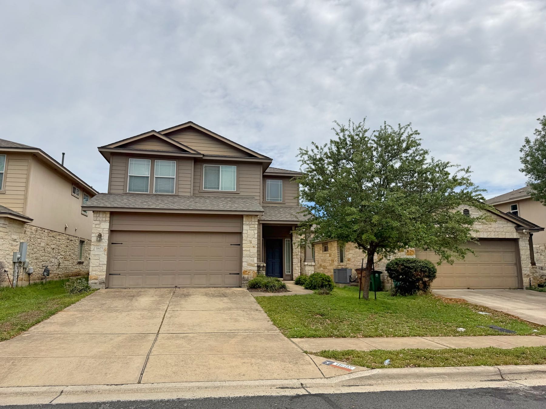 Two story home with two car garage and mature tree in Olympic Heights West Austin TX 78748