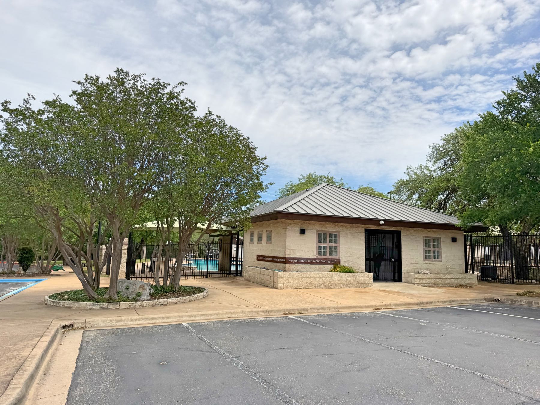 Capistrano Park pool clubhouse building with metal roof and gated pool access in Shady Hollow Austin TX 78748