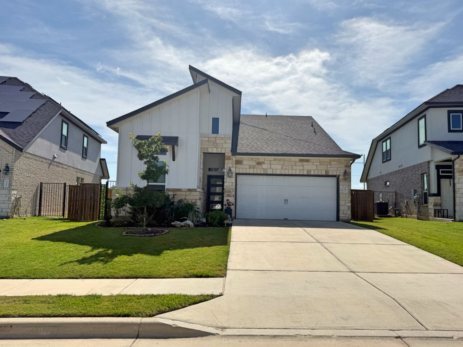 Two story white board and batten home in Cascades at Onion Creek Austin TX 78747